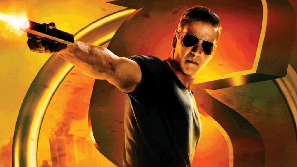 Akshay Kumar standing confidently with a muscular build, wearing a black sleeveless shirt and holding a firearm pointed upwards. with dynamic orange and yellow hues in the background suggesting an explosive action scene.