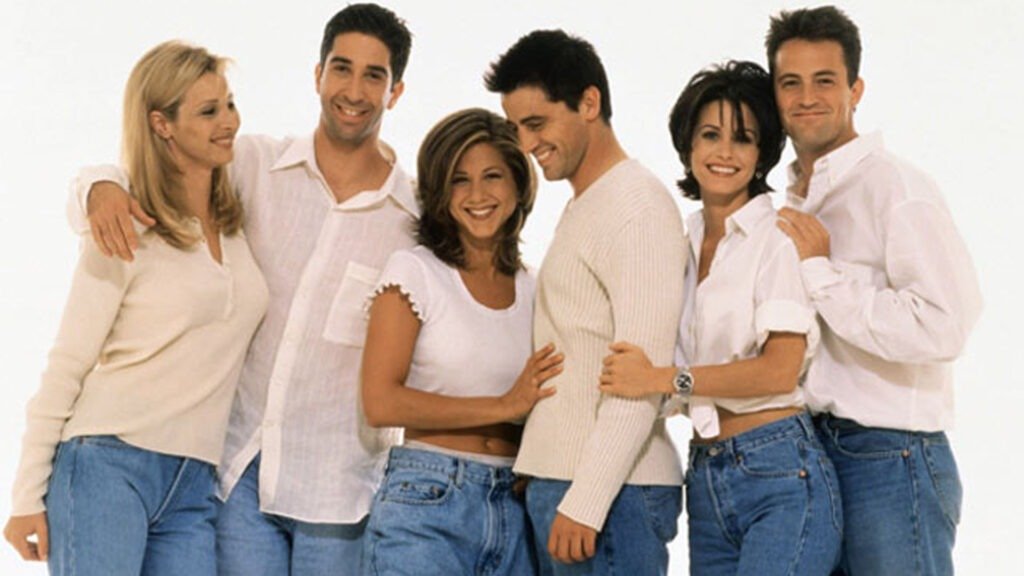 Group of six friends standing closely together, celebrating the 30th anniversary of Friends