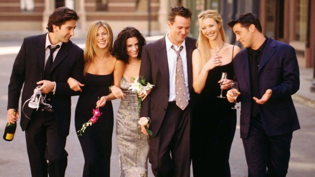 Group of six friends celebrating, dressed in formal attire with champagne and flowers, commemorating Friends 30th anniversary.