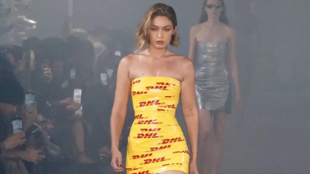 Gigi Hadid in DHL Dress: How This Tape Look Became 2024's Biggest Fashion Buzz 3 Gigi Hadid DHL Dress walking on runway