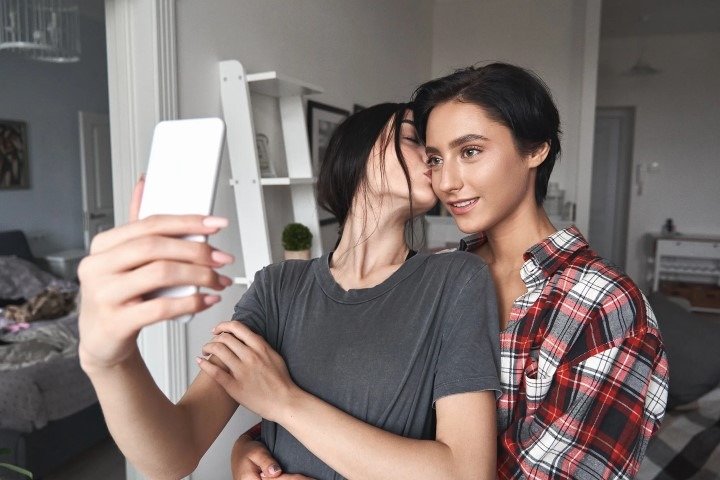 two Gen Z girl taking selfie with chick kiss