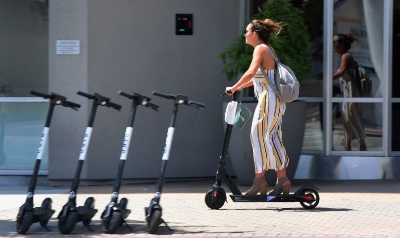 A Gen Z girl riding electric bike on a street.