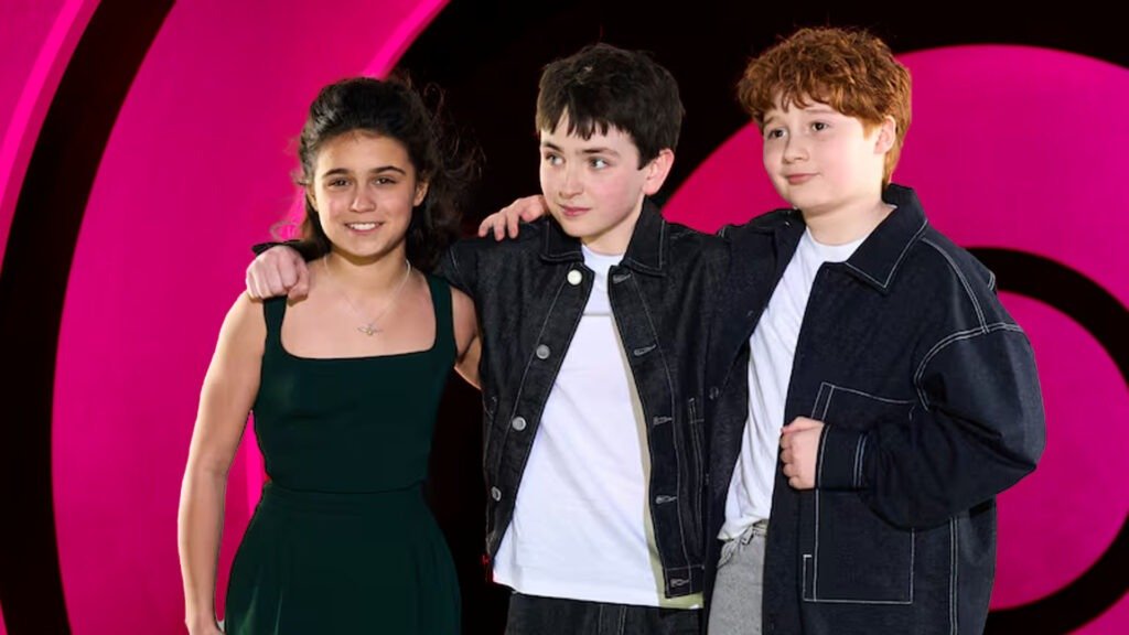 No Cap, the Harry Potter Trailer Just Reset the Entire Wizarding World 9 The new lead trio of the HBO Harry Potter series posing together at a London press event. In the center, Dominic McLaughlin (Harry Potter) wears a white t-shirt and black denim jacket; to his left, Arabella Stanton (Hermione Granger) in a dark green sleeveless dress; to his right, Alastair Stout (Ron Weasley) in a white shirt and oversized black denim jacket. They are standing against a vibrant magenta and black circular background.
Harry Potter Trailer